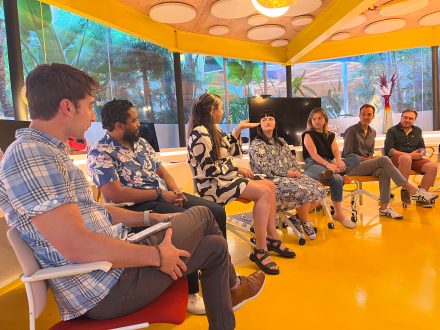 7 people seated in a row inside a bright, yellow room at Second Home Hollywood 