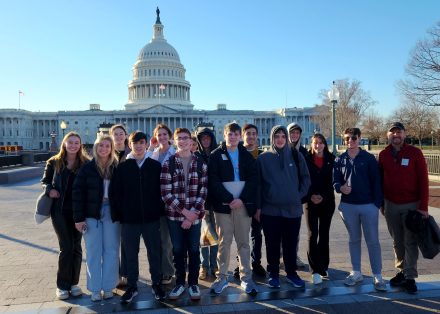 A group of 17 people posed in front of the Capitol Building