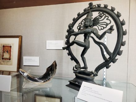 Shiva Nataraj statue, a shofar and other religious artifacts in a case