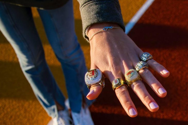 A hand with five CAA women's cross country championship rings