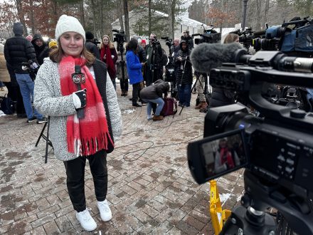 An Elon journalism student stands across a political campaign event in New Hampshire.