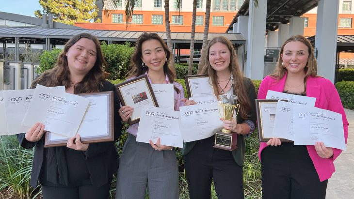 Four Elon students stand together with their Associated Collegiate Press awards.