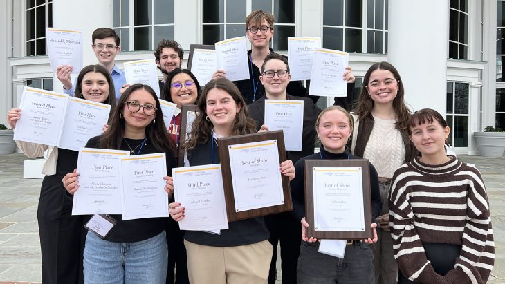 Elon students hold up awards while attending NC College Media Association conference.