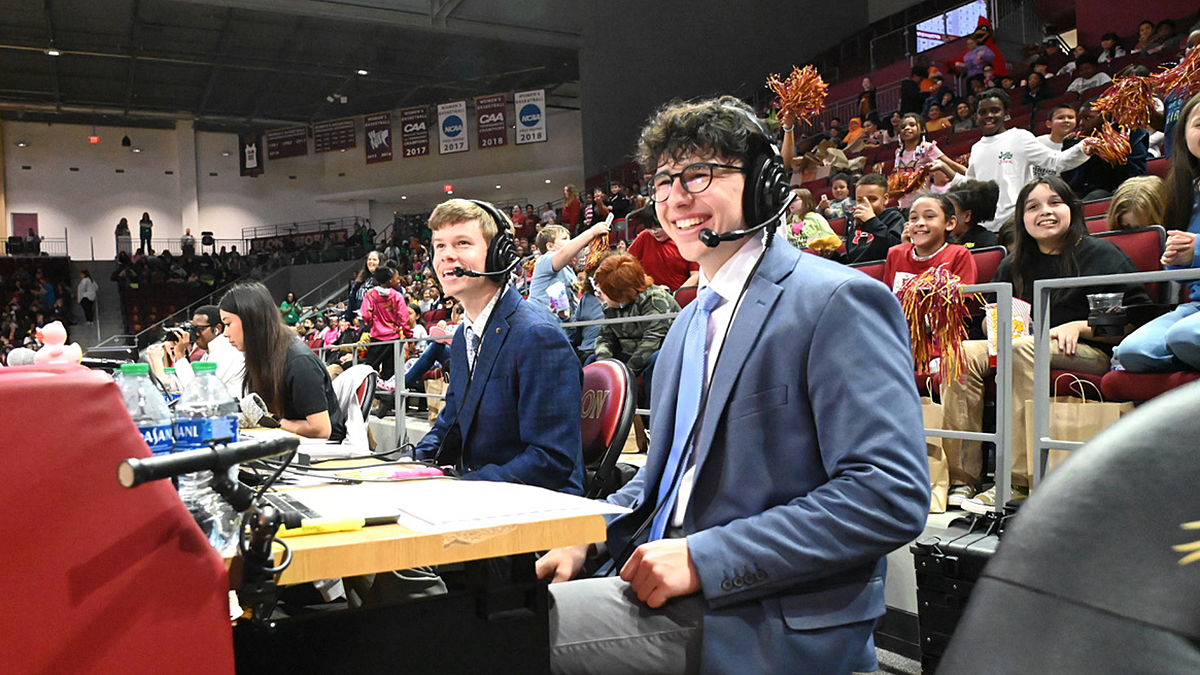 Max Wallace, an Elon student, sits on press row in Schar Center.