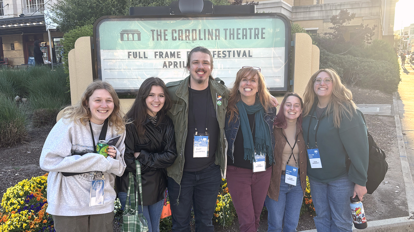 Elon film students stand in front of Carolina Theatre sign in Durham, North Carolina.