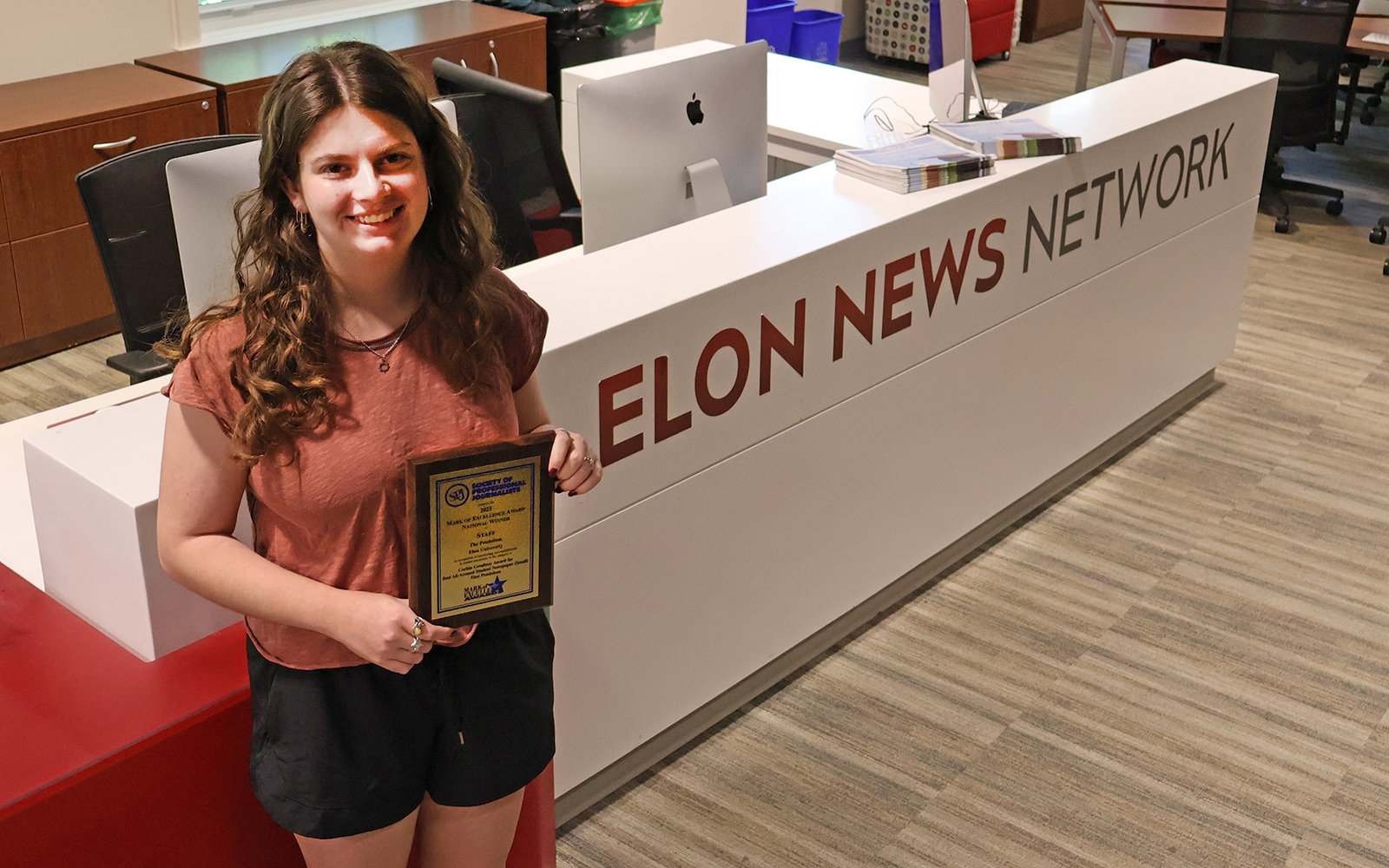 Avery Sloan of ENN stands in newsroom.