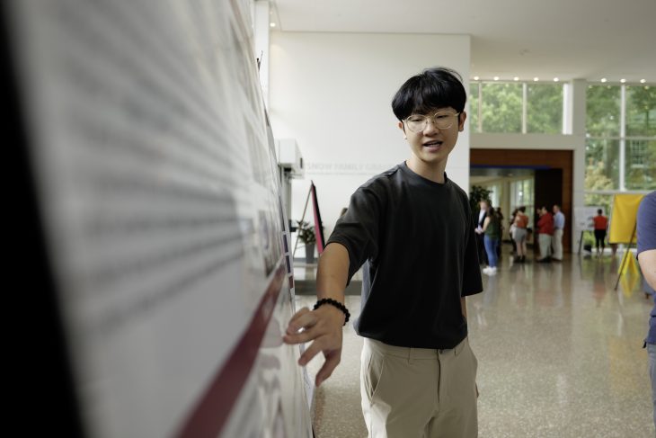 Person points to poster board and speaks