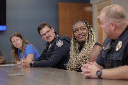 Four people sit at table.