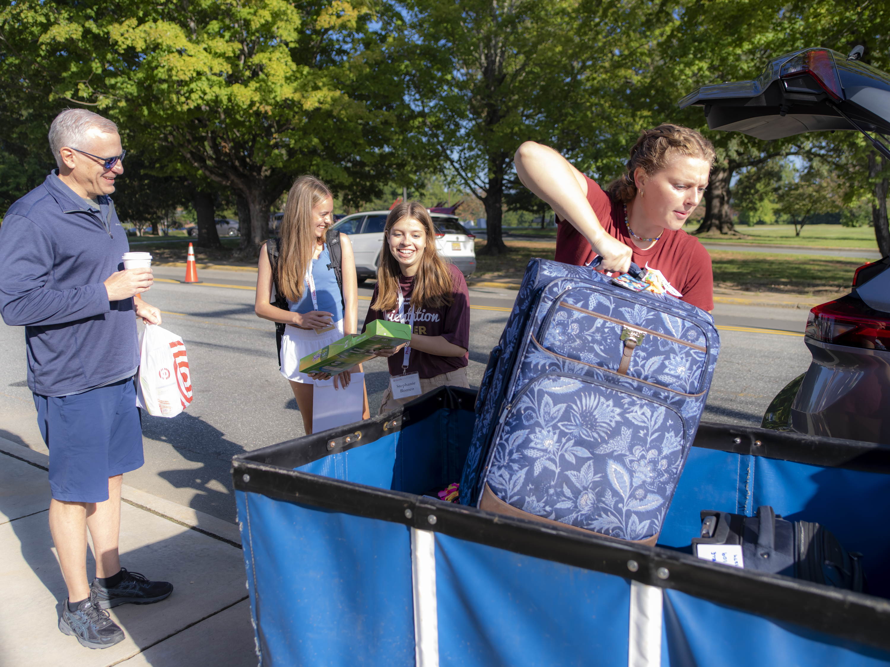 Elon student puts a suitcase in a bin