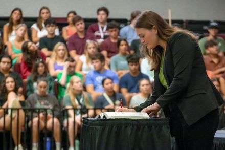 Elon student signs book