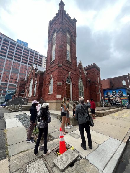 Group of people stand in front of building in Charlotte on a tour