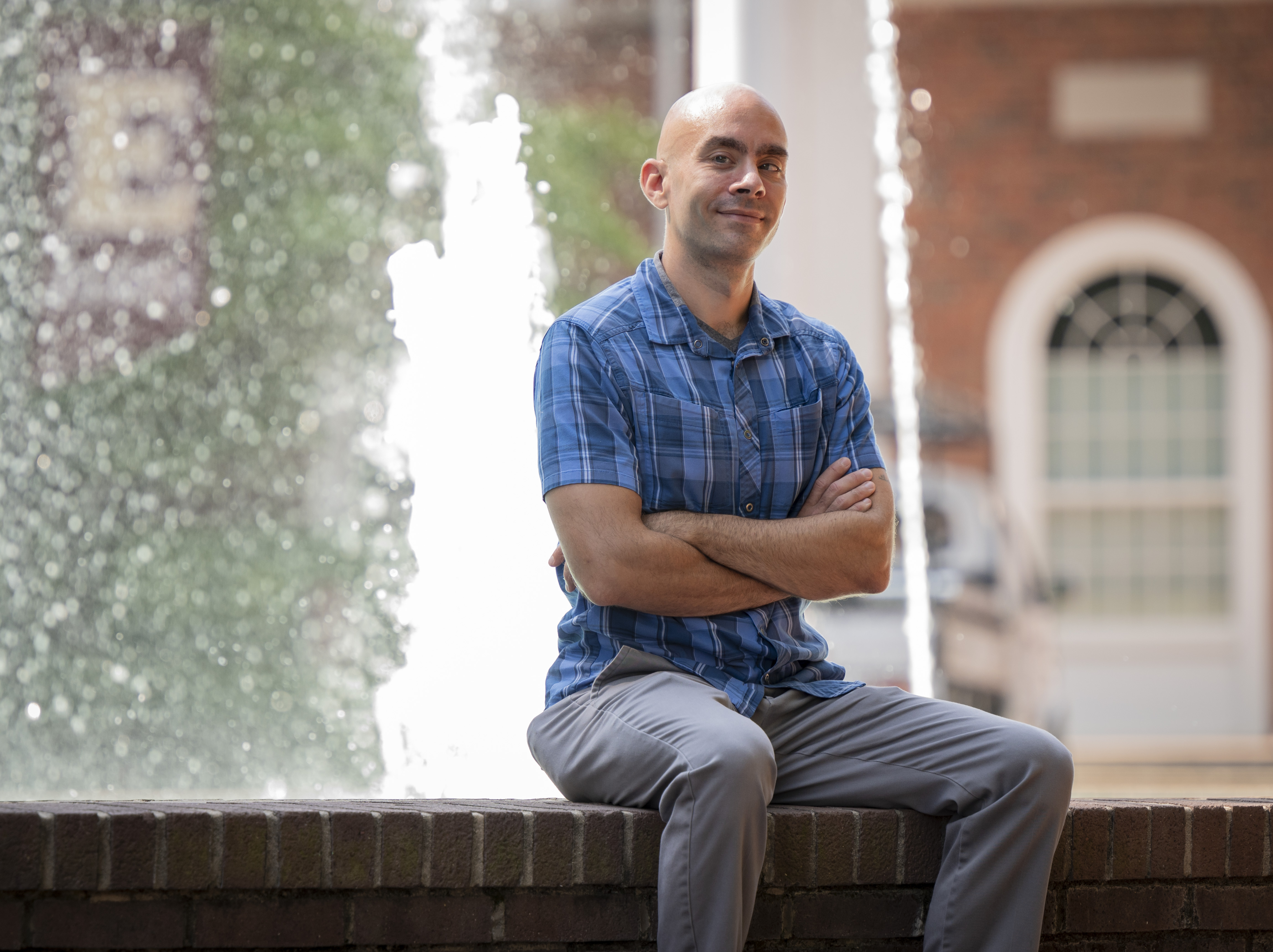 Andrew Monteith in a blue shirt in front of the Alamance Building fountain