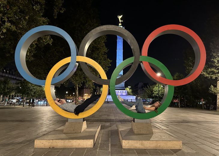 Two people lay in the Olympic rings in Paris