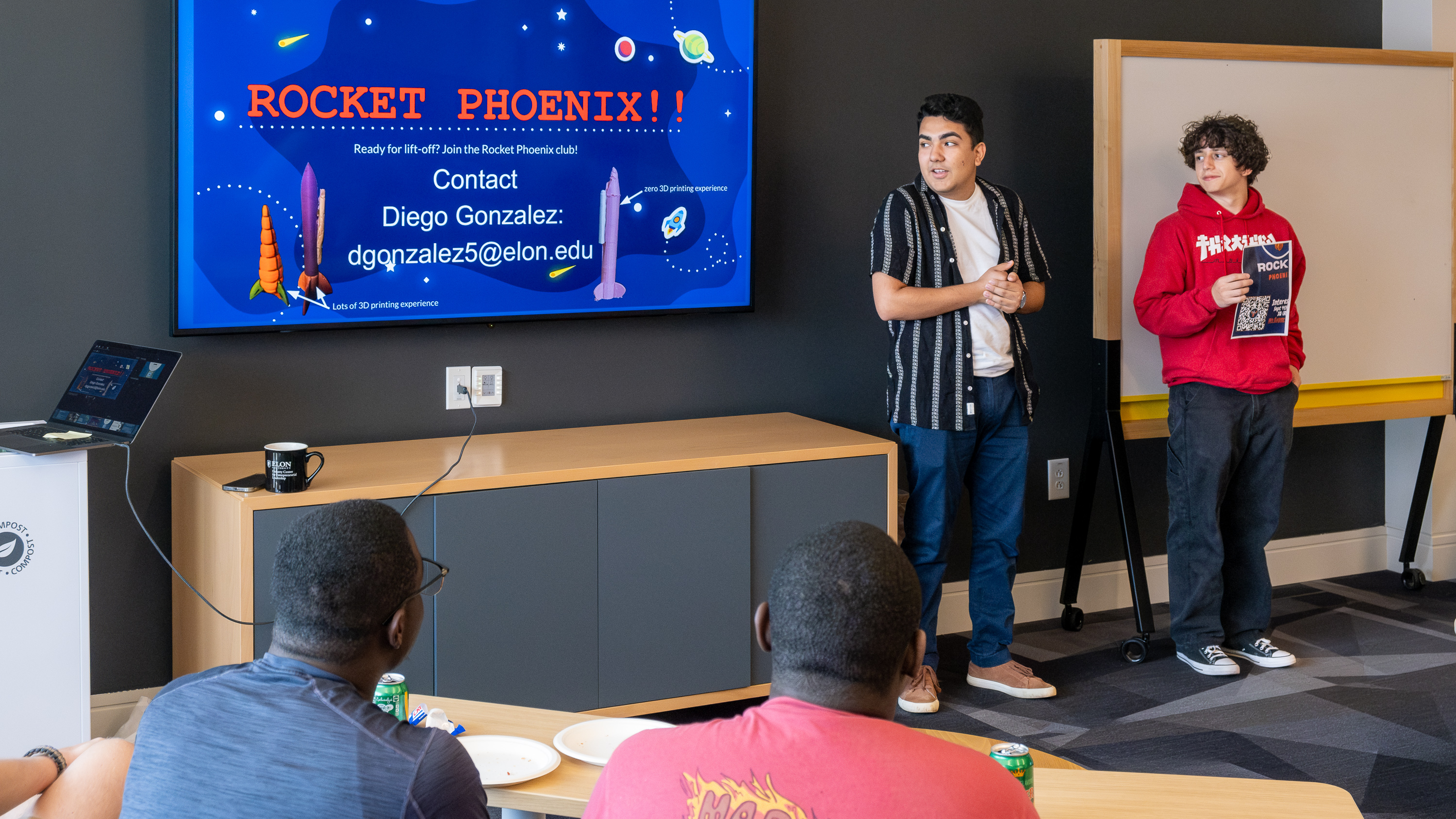 Two people stand in front for a presentation