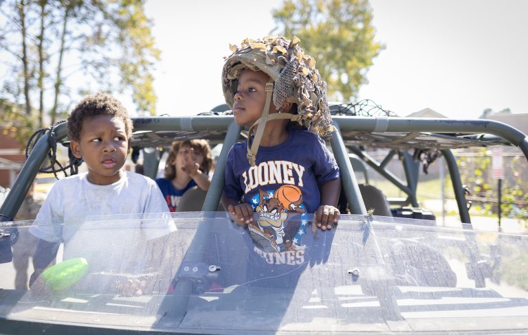 Child wears military helmet