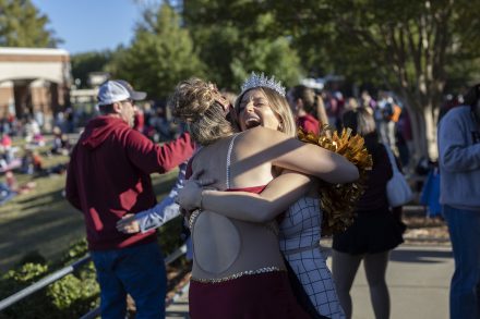 2023 Homecoming Royalty hugs friend during Homecoming 2023