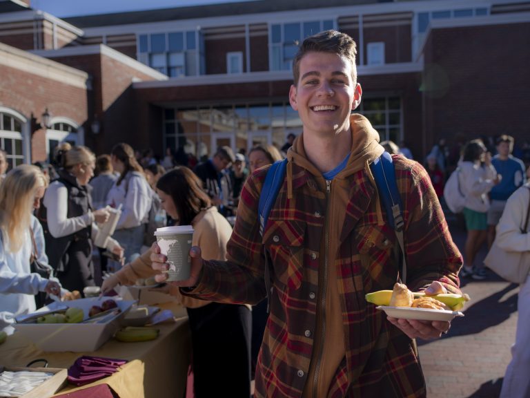 A person poses with food during College Coffee