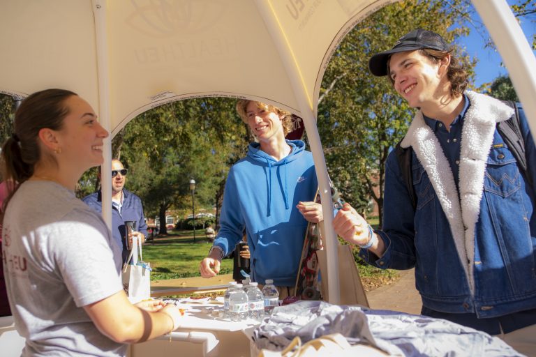 Two students speak with a person on HealthEU Day