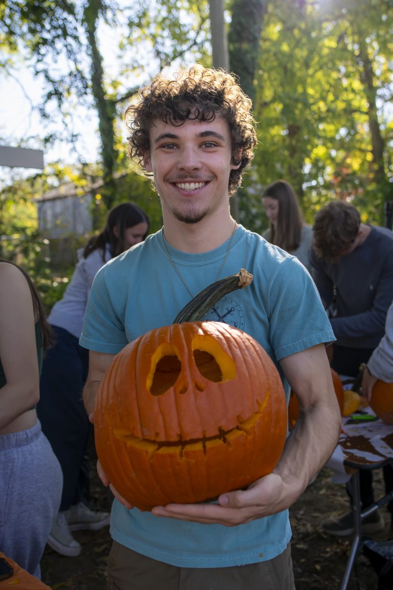 Person holds carved pumpkin