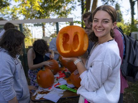 Person holds carved pumpkin