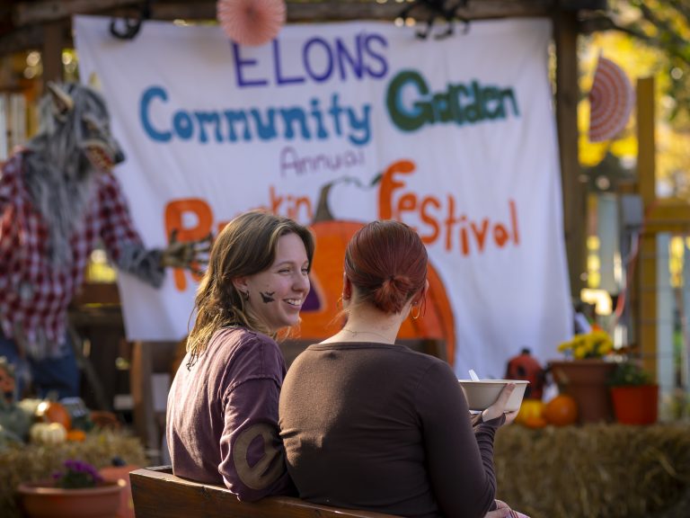 Two people sit at pumpkin festival