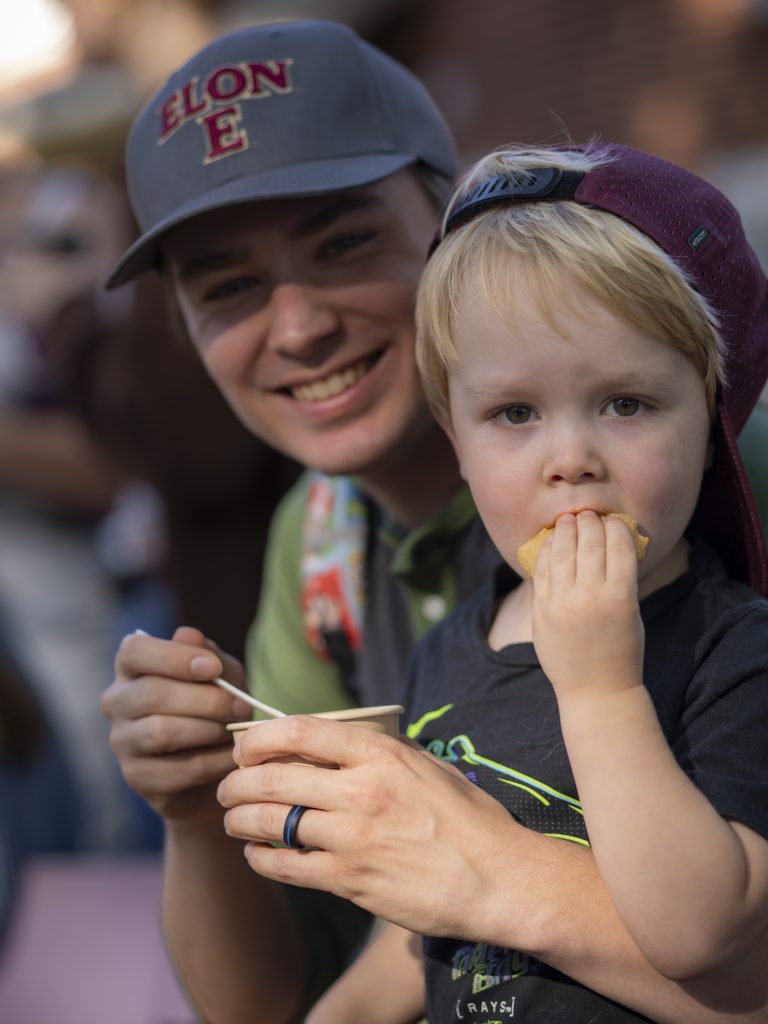 Child eats while being held by person