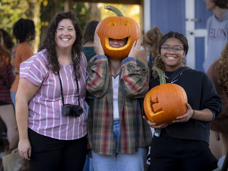 Three people pose at Pumpkin Festival