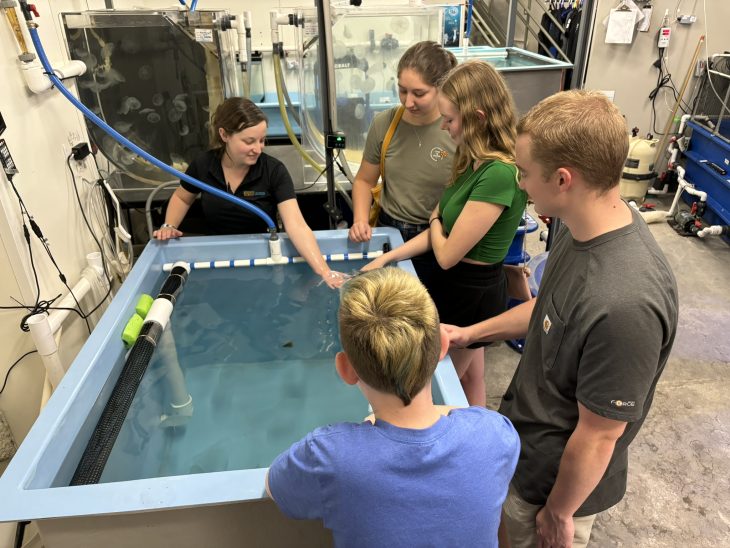 Students stand around a tank of water