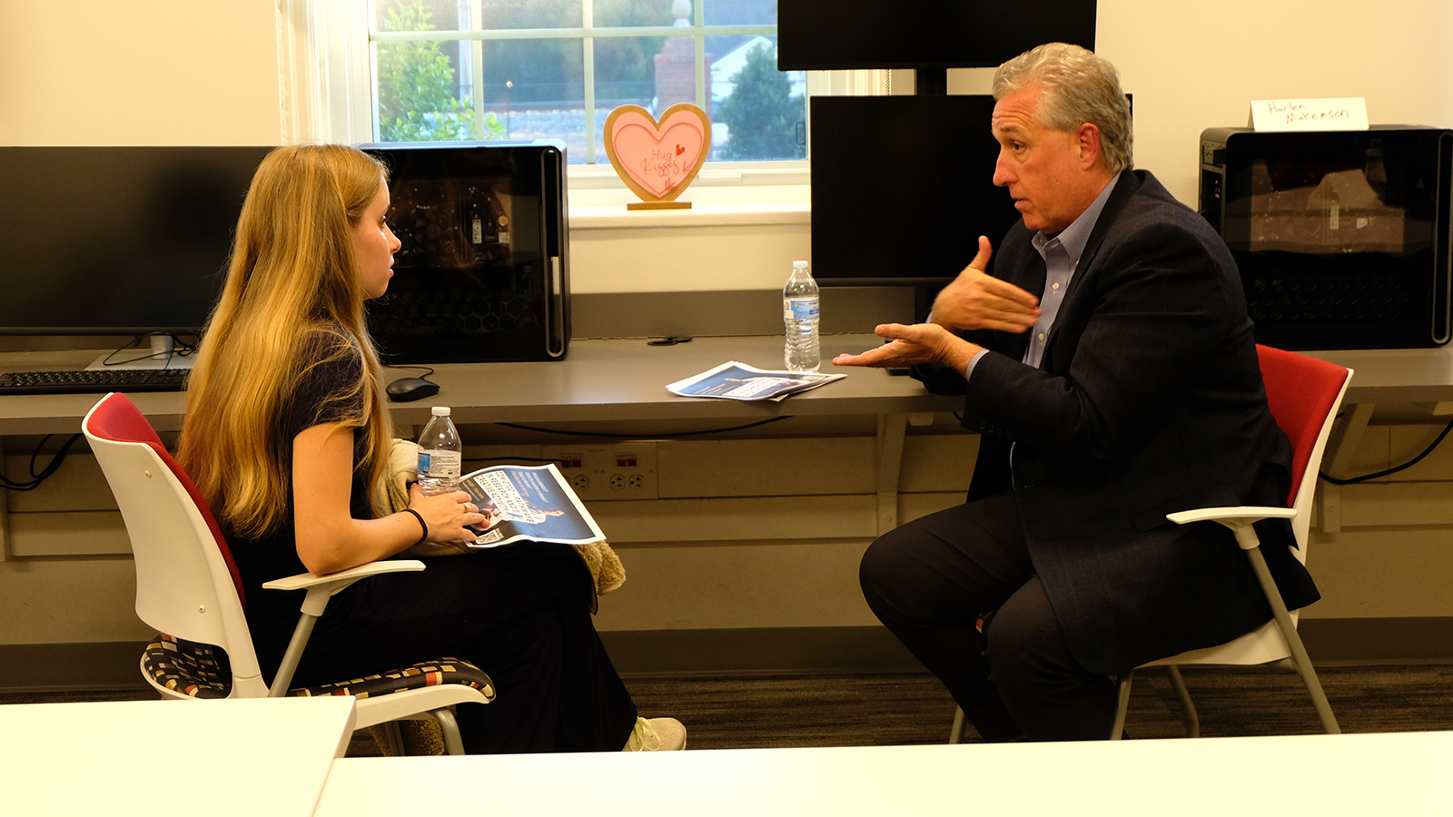 Harlen Makemson, Elon professor, speaks with a student.