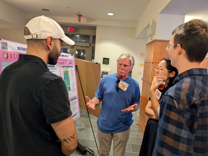 People talk around a research presentation board