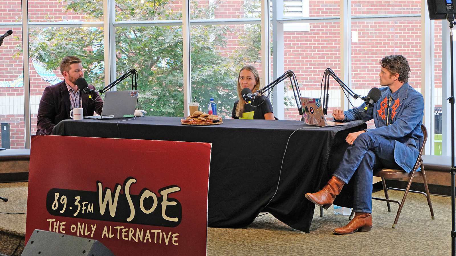 Three podcasters sit while taping at Elon University.