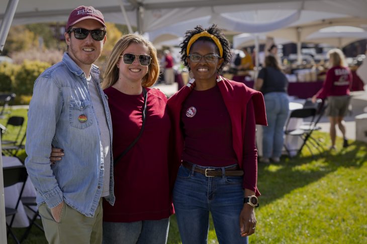 Three people pose at Elon Homecoming