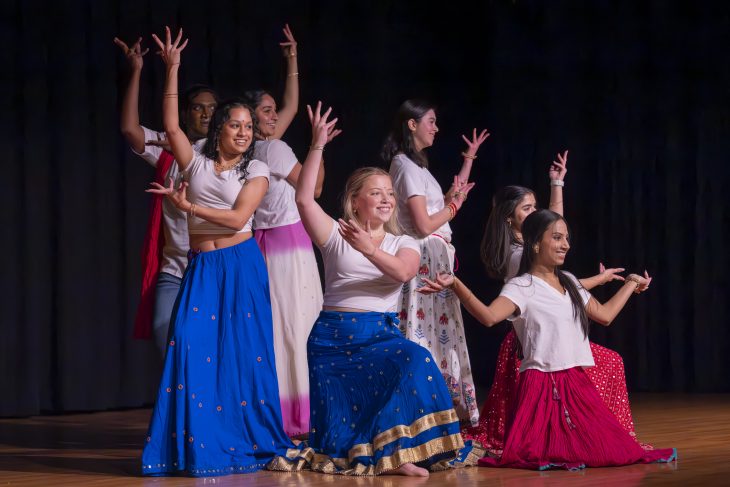 Dancers have their hands raised on stage