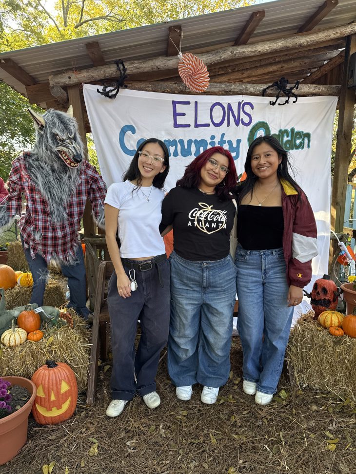 Three people stand at pumpkin festival