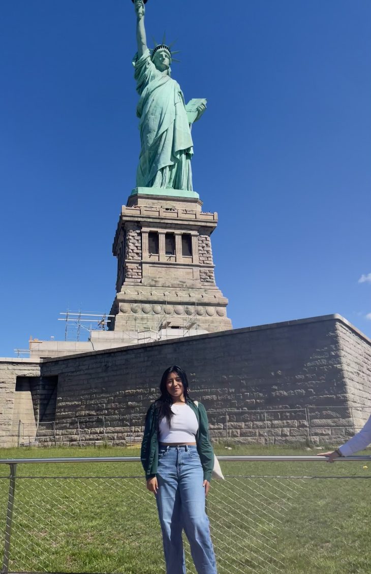 Anahy Felipe De La Cruz in front of the Statue of Liberty.