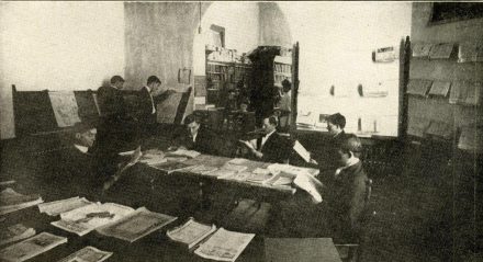 Elon University students gathered around a reading room table circa 1907