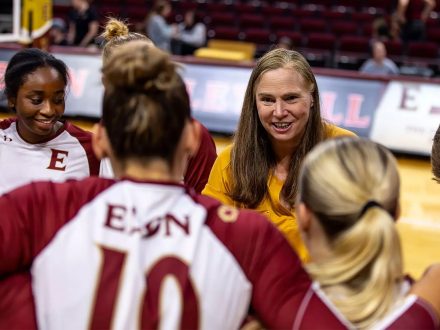 Mary Tendler talks to Elon Volleyball players on the court