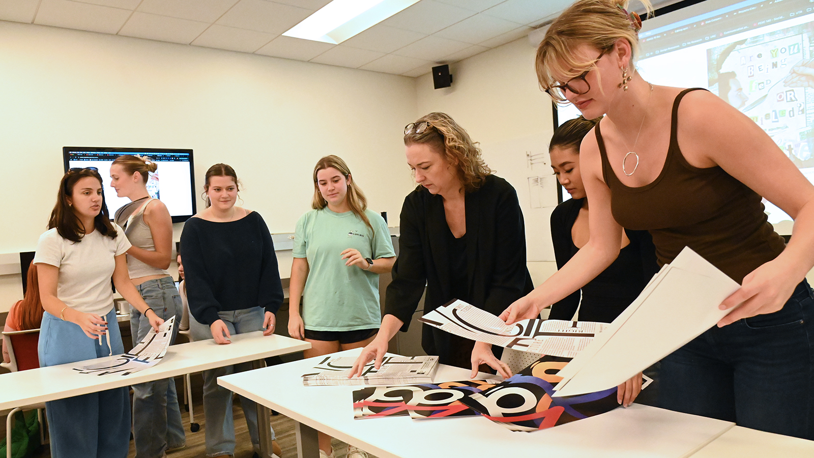 Communication design students sort through posters.