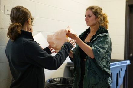 Two students hold a silicone mold for a robotic quadruped they built.