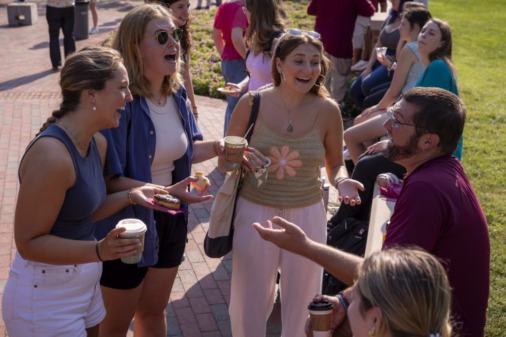 Several students talk to one another with coffee