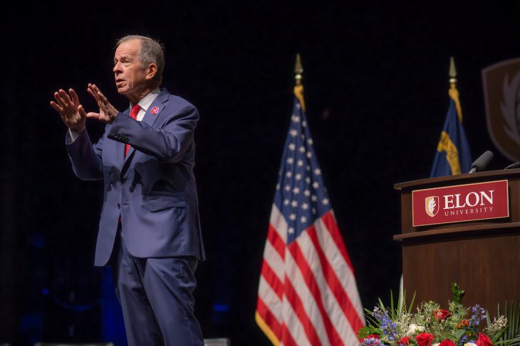 Ret. Adm. Mike Mullen stands on a stage next to an American flag on the campus of Elon University during a visit on Nov. 11, 2024