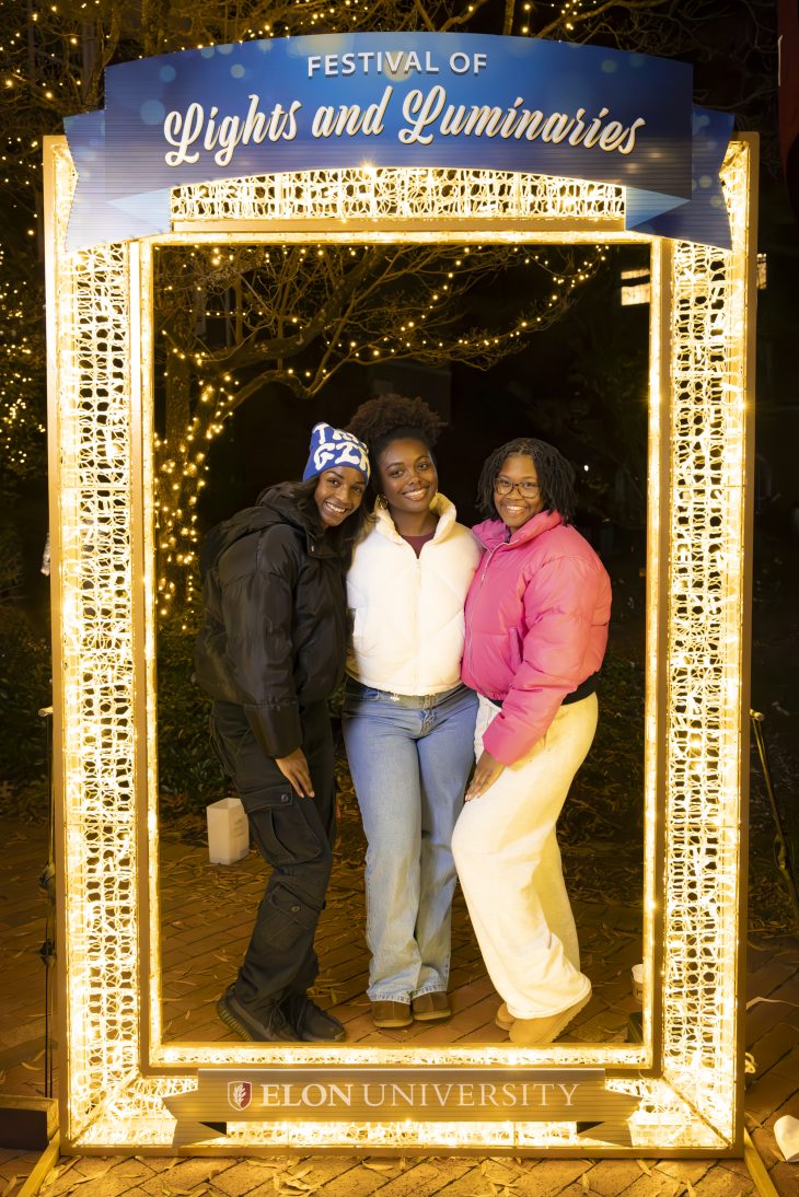 Three people pose in a frame