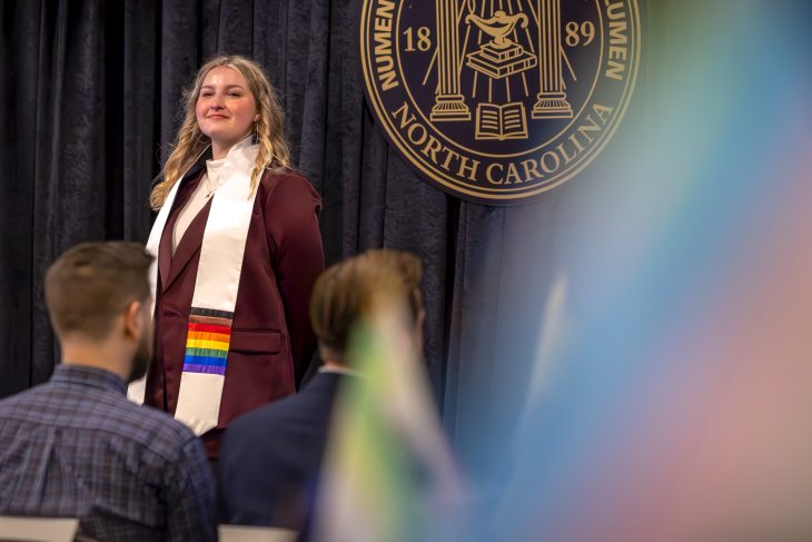 Person stands with a rainbow stole