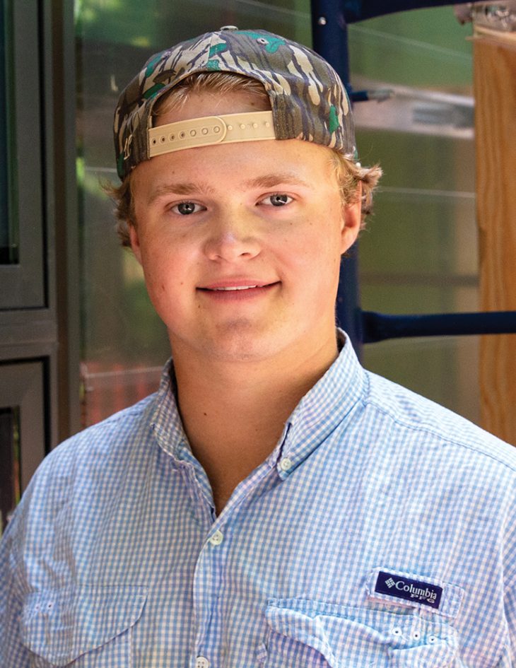 Headshot of a young man wearing a baseball cap backwards