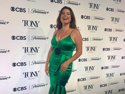 Woman in green dress miles on Tony Awards red carpet