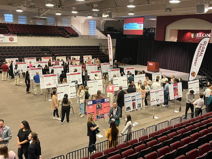 People mingle amid poster board presentations