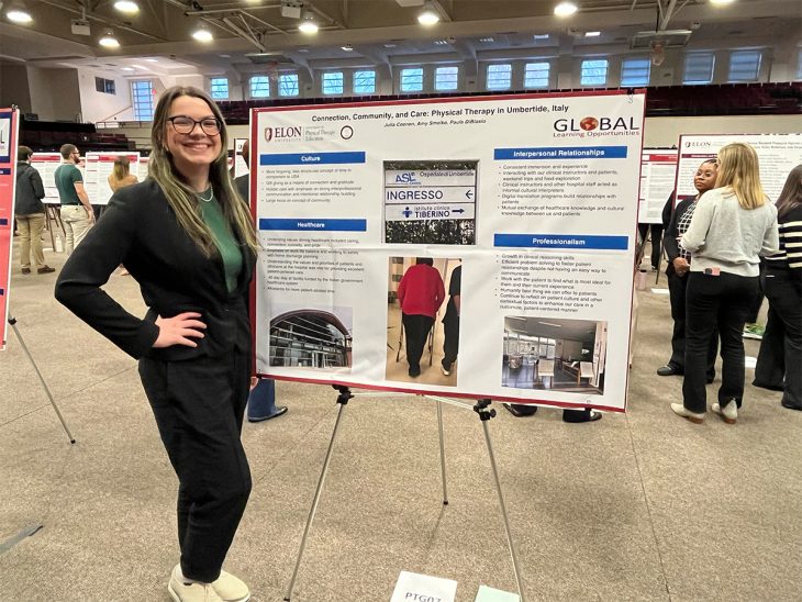 Julia Coenen stands beside poster board and smiles