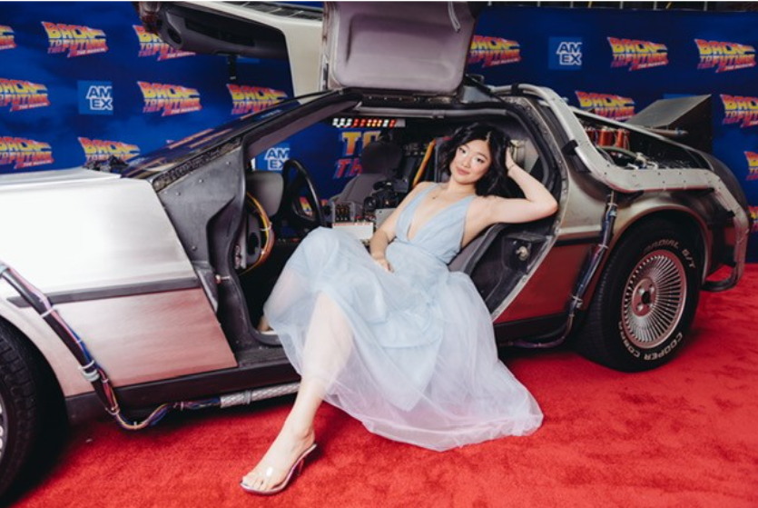 Hannah Kevitt poses in a DeLorean on a red carpet