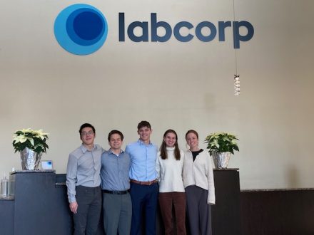 Five students pose in front of a Labcorp sign