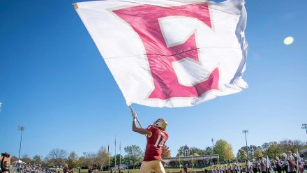 Football player waves large flag with an E on the flag